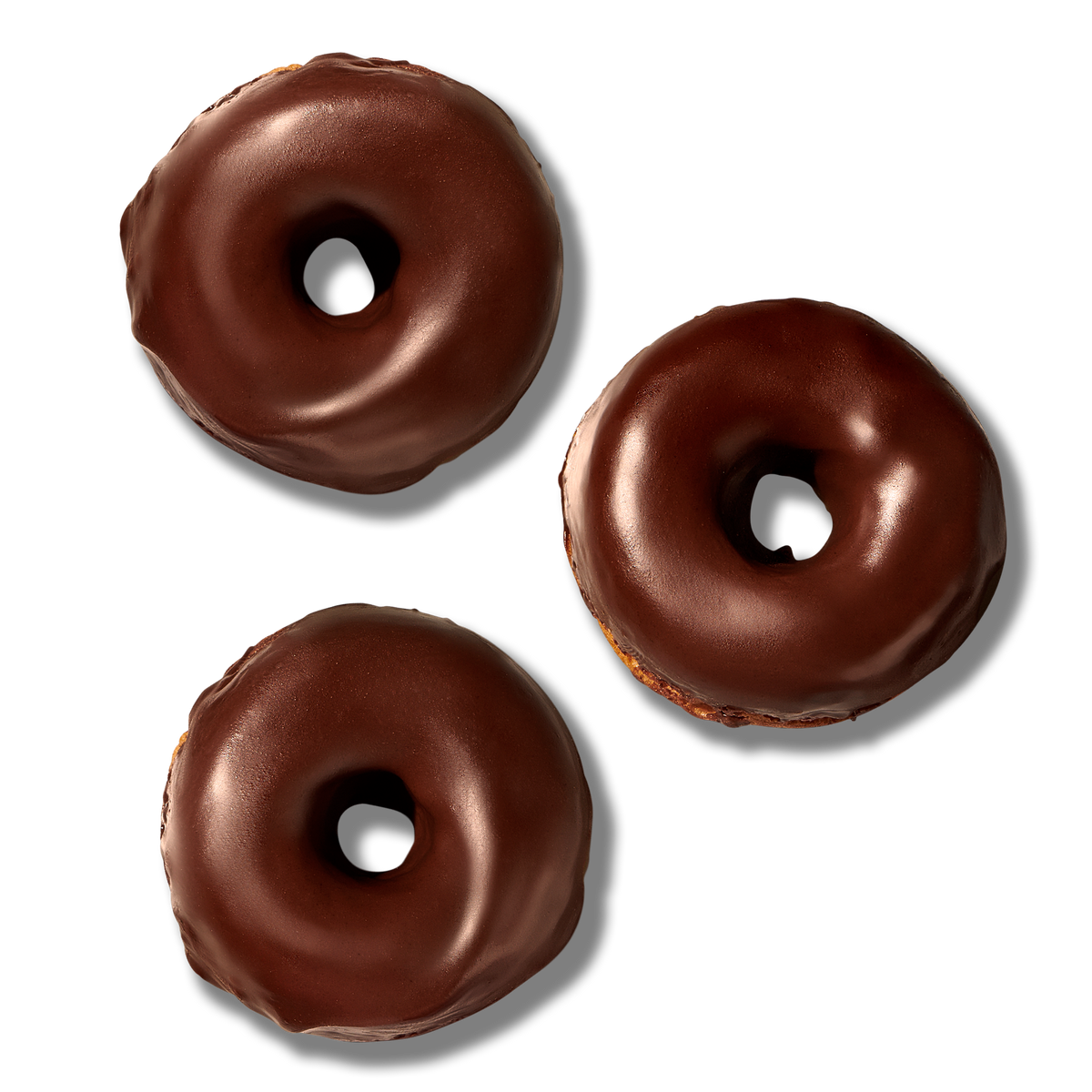 Three The Bruce Chocolate Frosted Donuts, made with sorghum flour and cane sugar, are arranged on a plain white background, each featuring a smooth, glossy chocolate coating and the classic hole in the center.
